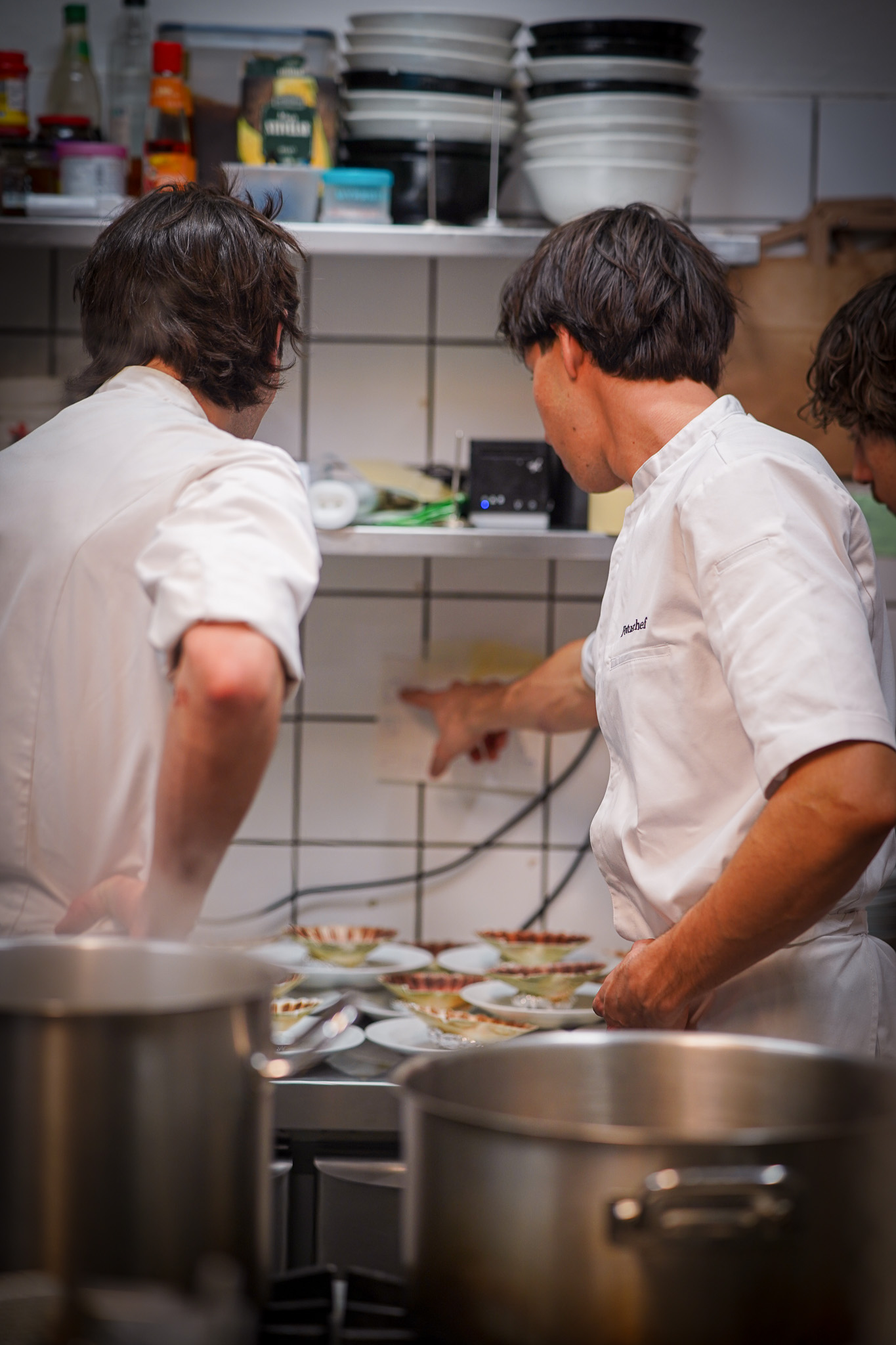 Lorenzo torching scallops with a blowtorch, flames visible