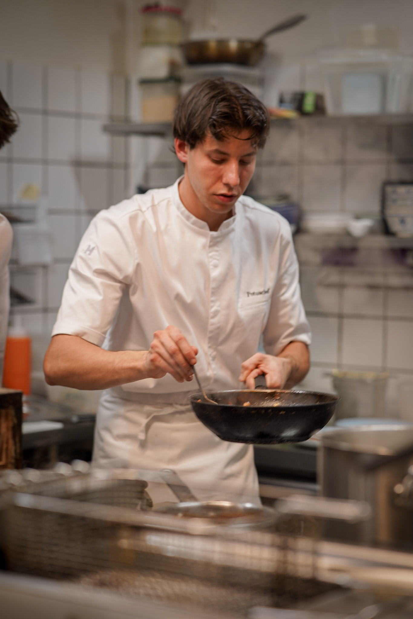 Lorenzo tasting and tossing a pan of sauce