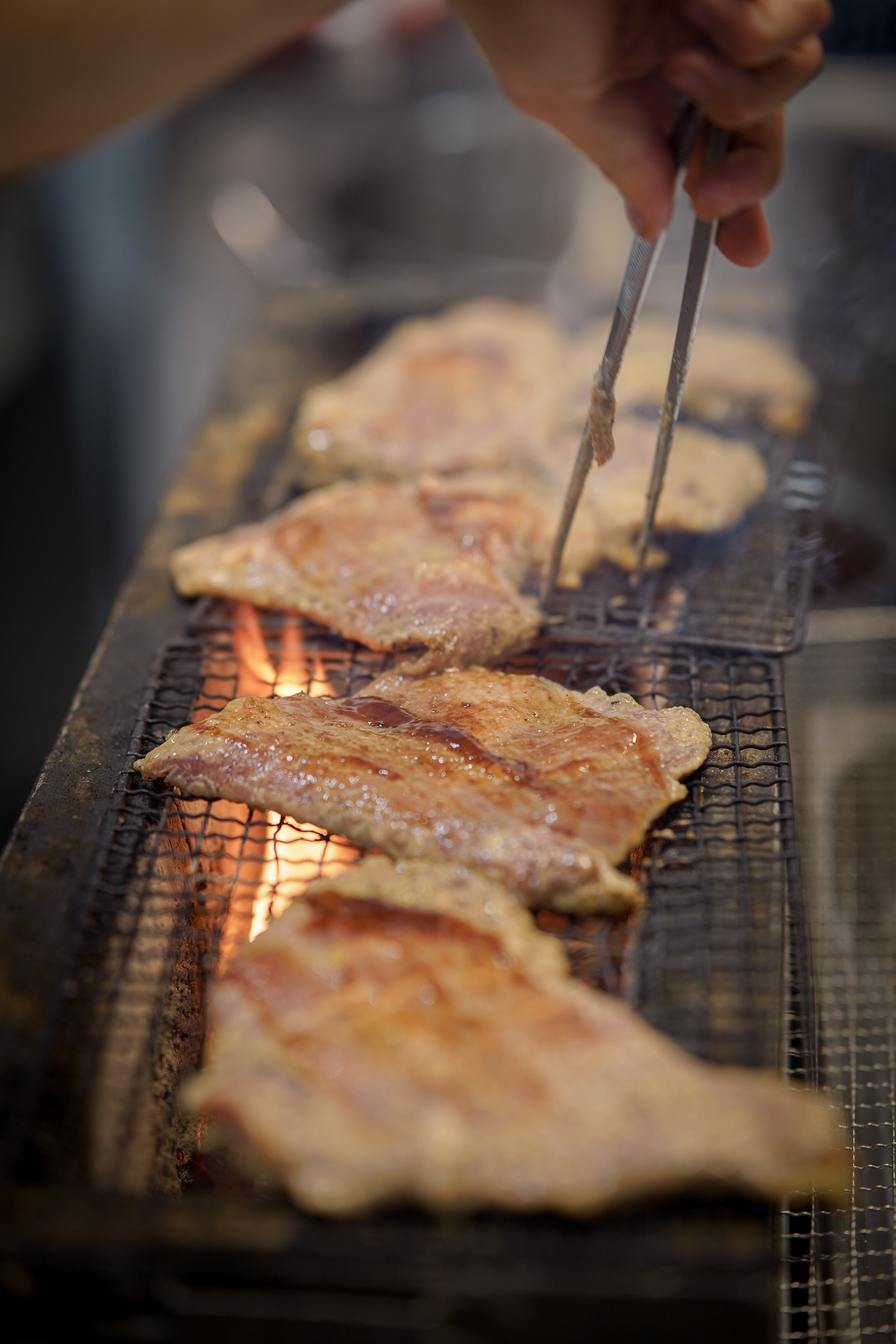 Meat grilling over an open flame with sparks flying